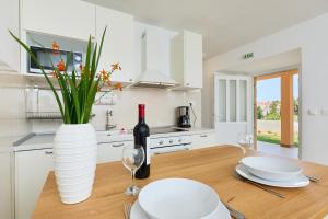 uma cozinha com uma mesa de madeira e uma garrafa de vinho em Guest House Anica em Dubrovnik