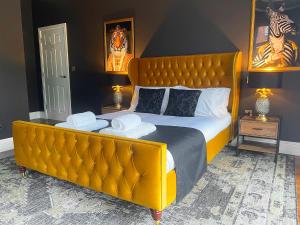 Selworthy - Luxury 3 Bedroom Apartment في يوفيل: سرير كبير مع اللوح الأمامي الأصفر الكبير في غرفة النوم