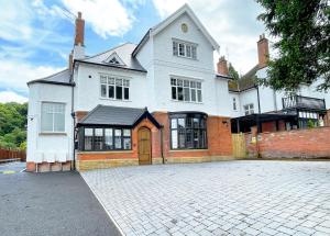 a large white house with a large driveway at Selworthy - Luxury 3 Bedroom Apartment in Yeovil