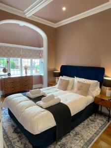 a bedroom with a large bed with a blue headboard at Selworthy - Luxury 3 Bedroom Apartment in Yeovil