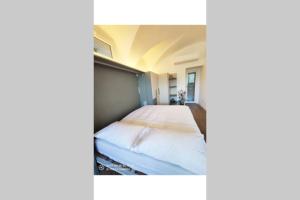 1 dormitorio con 1 cama grande con sábanas blancas en Gioiello sul lago d'Iseo, en Sale Marasino