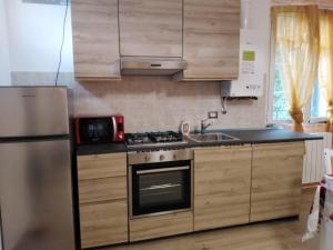 a kitchen with a stove and a sink and a refrigerator at La Casetta di Sofia 2 in Moneglia