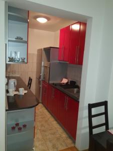 a kitchen with red cabinets and a counter top at Apartman Basic Doboj in Doboj