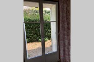 an open window with a view of a yard at Le Clos de l'Eglise - Blanche in Giverny