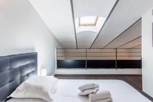 - une chambre avec un grand lit et une lucarne dans l'établissement APPARTEMENT HAUSSMANNIEN TYPE LOFT, CLIMATISE - VIEUX-PORT-LE PANIER,, à Marseille