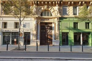 - un bâtiment avec une grande porte en bois dans une rue dans l'établissement APPARTEMENT HAUSSMANNIEN TYPE LOFT, CLIMATISE - VIEUX-PORT-LE PANIER,, à Marseille