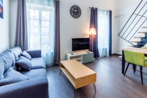 uma sala de estar com um sofá azul e uma mesa em APPARTEMENT HAUSSMANNIEN TYPE LOFT, CLIMATISE - VIEUX-PORT-LE PANIER, em Marselha