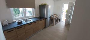 a kitchen with a stainless steel refrigerator and a table at Apartment Angela in Šibenik