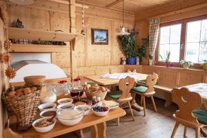 Habitación con paredes de madera, mesas y sillas. en Binterhof ROSALPINA APP, en Castelrotto