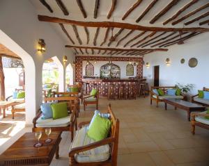 a room with chairs and tables and a bar at Sultan Sands Island Resort & Spa in Kiwengwa