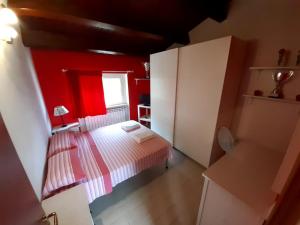 a small bedroom with a bed and a red wall at Casale Angela in Torrevecchia Teatina