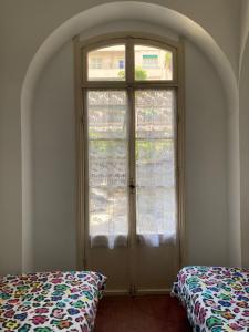 a room with a window and a bed in front of it at Hôtel Belle Meunière in Nice