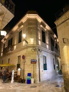 a building at night with a man standing in front of it at Dimora San Biagio Suites&Apartment in Lecce