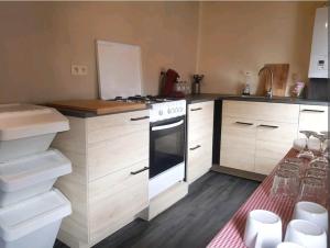 a kitchen with white cabinets and a stove top oven at Charmante maison lumineuse au coeur de Liège! in Ans