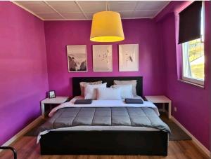 Dormitorio púrpura con cama y lámpara amarilla en Charmante maison lumineuse au coeur de Liège!, en Ans