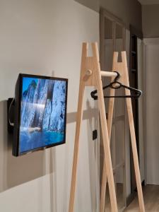 a television hanging on a wall next to a ladder at TAM Center Studio Apartment Next To Blloku No1 in Tirana