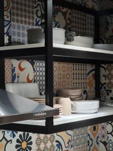 a shelf filled with plates and dishes on a wall at TAM Center Studio Apartment Next To Blloku No1 in Tirana