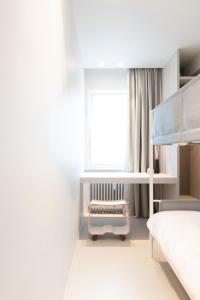 a bedroom with a bunk bed and a window at Een designappartement met zijdelings zicht op zee in Ostend