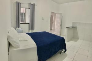 a white bedroom with a blue blanket on a bed at Amigos da Praia - Nova Administração in Fortaleza