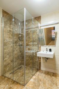 La salle de bains est pourvue d'une douche et d'un lavabo. dans l'établissement Wood Fairy, à Korenica