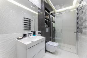 a white bathroom with a sink and a shower at Leo Apartament Delux in Ustrzyki Dolne