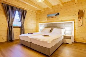 a bedroom with a large bed in a wooden room at Wood Fairy in Korenica
