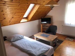 a bedroom with a bed and a table with a chair at Pacsirta Apartman in Lenti