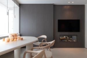 TV a/nebo společenská místnost v ubytování Een designappartement met zijdelings zicht op zee