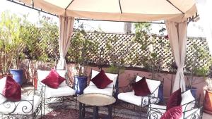 a patio area with chairs, tables, and umbrellas at Arabian Riad Marrakech in Marrakech
