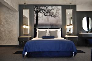a bedroom with a blue bed and two mirrors at Skopea Inn Exclusive Hotel in Göcek