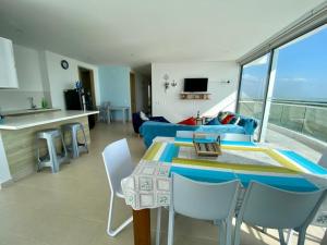 eine Küche und ein Wohnzimmer mit Tisch und Stühlen in der Unterkunft Magico Apartamento Frente al Mar 3 Habitaciones FB73 in Coveñas