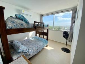 2 Etagenbetten in einem Zimmer mit einem großen Fenster in der Unterkunft Magico Apartamento Frente al Mar 3 Habitaciones FB73 in Coveñas
