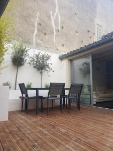 a patio with a table and chairs on a deck at Maison vue Cité 2 in Carcassonne