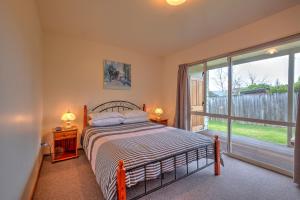 a bedroom with a bed and a large window at 42b Conical Hill Road in Hanmer Springs