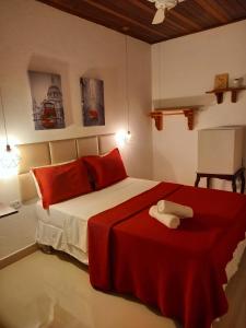 sypialnia z dużym łóżkiem z czerwonymi poduszkami w obiekcie Pousada Schueng w mieście Trindade