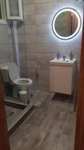 a bathroom with a toilet and a sink and a mirror at Athina View Studio in Néa Péramos +22 photos