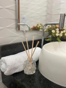 a bathroom counter with a sink and a towel at Suítes Pezzin in Paragominas