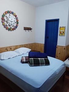 a bedroom with a bed with a clock on the wall at Hospedaria e Hostel da Déia in Ouro Preto