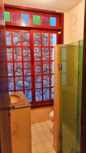baño con ventana colorida y lavamanos en Varandas do Arraial- Hostel en Arraial do Cabo