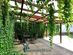a patio with a table and chairs under a pergola at Pension zum Hirsch in Hattersheim