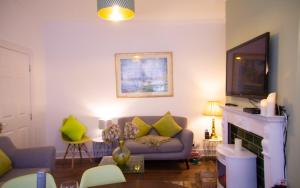 ein Wohnzimmer mit einem Sofa und einem Kamin in der Unterkunft Beautiful Victorian Terraced House in Eastbourne