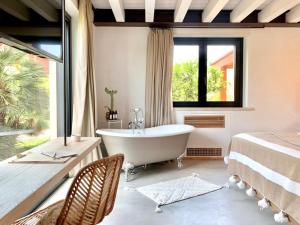 a bathroom with a tub and a bed and a window at Santa Lucia Maccarese - Residenza Agricola in Maccarese