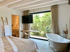 a bedroom with a bed and a tub and a window at Santa Lucia Maccarese - Residenza Agricola in Maccarese