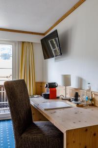 a kitchen with a wooden table with a television on the wall at Landgasthof Sternen in Bühler