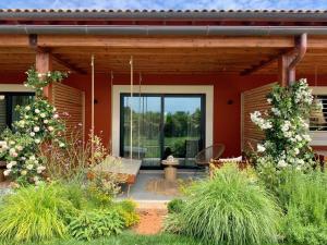 a red house with a porch with a patio at Santa Lucia Maccarese - Residenza Agricola in Maccarese