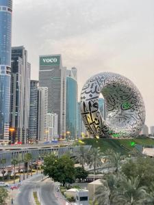 a large sculpture of a donut in front of a city at Travelers Backpackers in Dubai