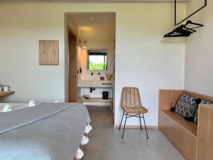 a bedroom with a bed and a chair in it at Santa Lucia Maccarese - Residenza Agricola in Maccarese