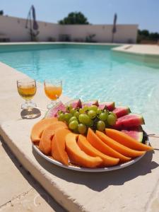 un plato de fruta en una mesa junto a una piscina en B&B Casina Le Rene, en Poggiardo