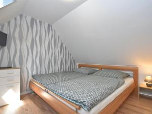 1 dormitorio con 1 cama con cabecero de madera en Apartment in Timmenrode with private garden, en Timmenrode