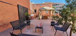 a patio with chairs and a table and an umbrella at Villa Rosa Boutique in Almancil
